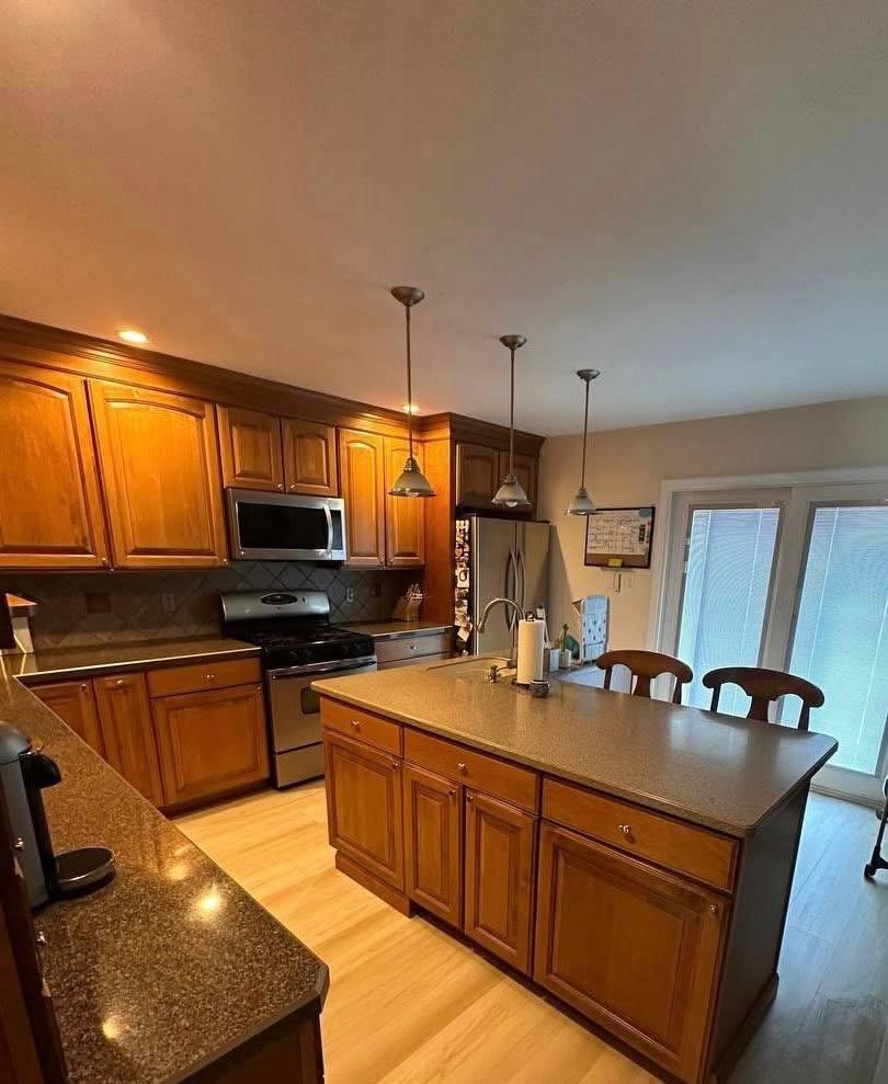Wood kitchen with island, counters cleared and shining